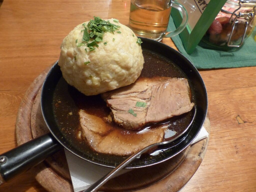 Schweinebraten mit glasierten Apfelspalten und Semmelknödel